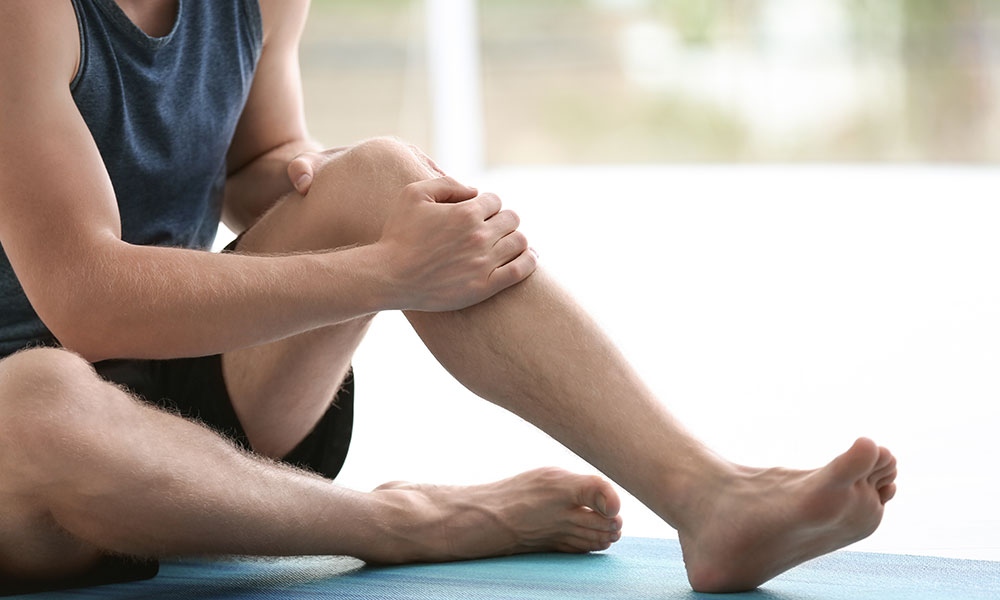 Man in suffering from leg muscle spasms